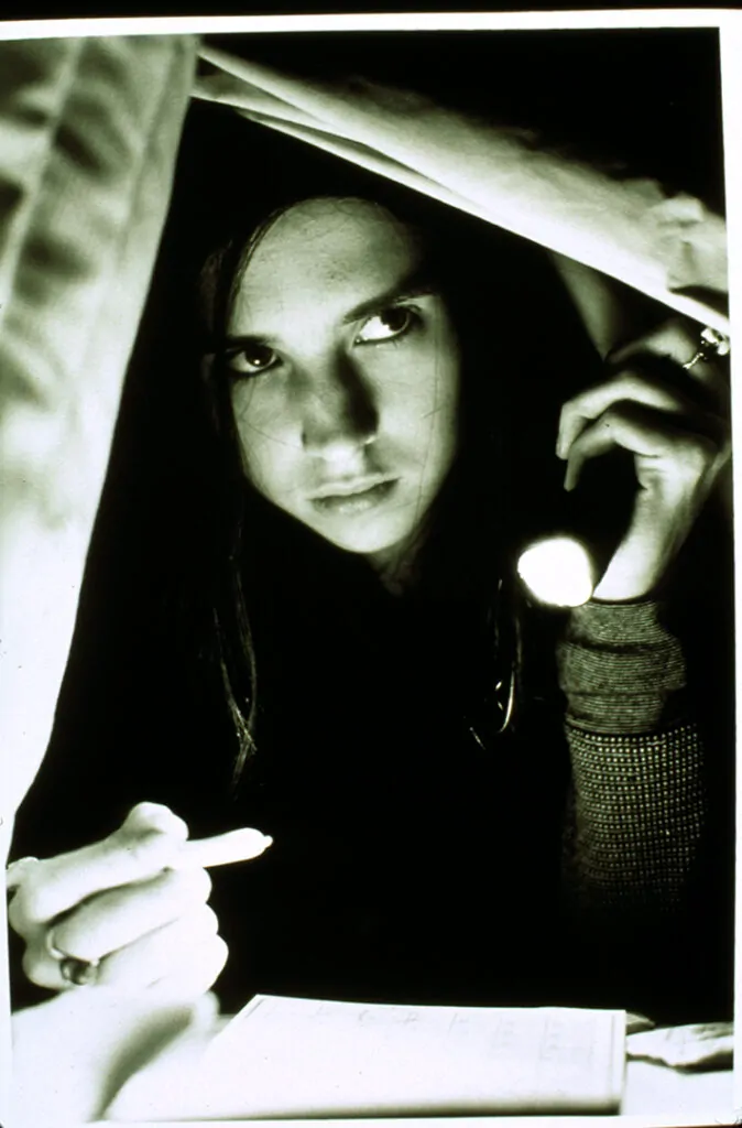 Emily Perkins as Brigitte Fitzgerald in GINGER SNAPS with bone pen and necklace (Credit: Lionsgate)
